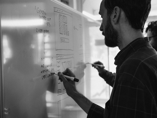 Designer on whiteboard sketching