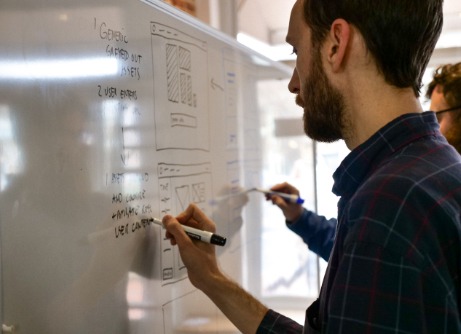 Designer writing ideas on whiteboard