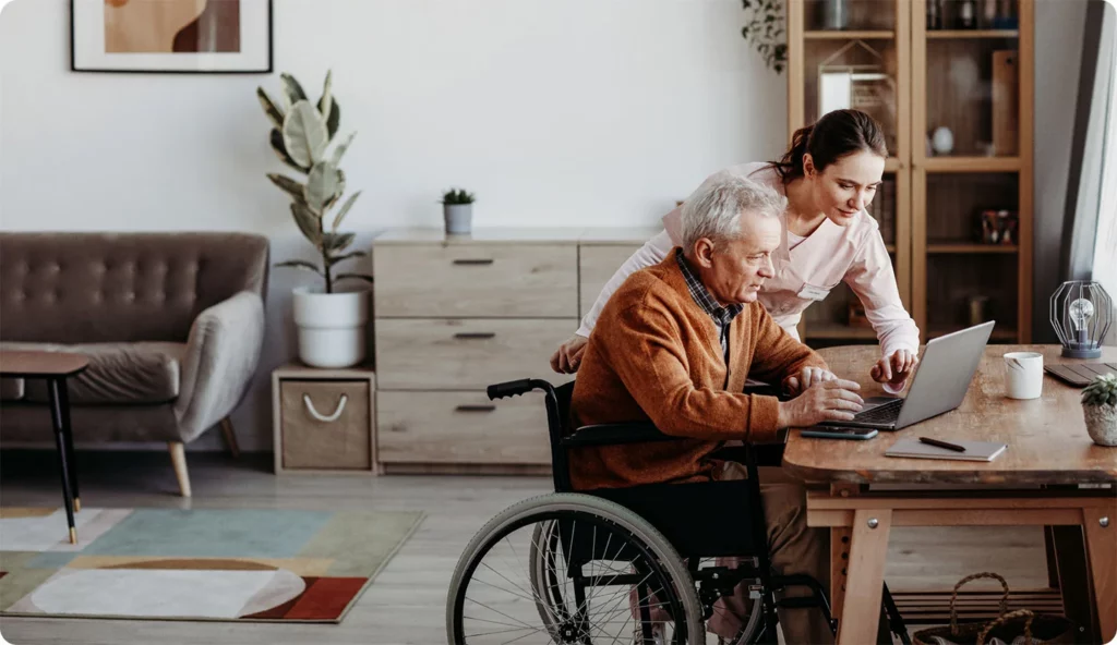 nurse helping senior with laptop